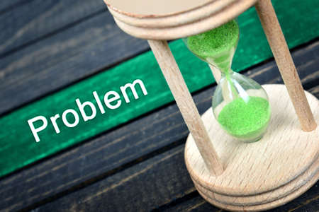 Problem text and hourglass on wooden tableの写真素材