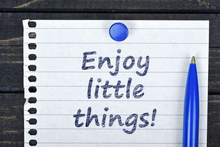 Enjoy little things text on page and pen on wooden tableの写真素材