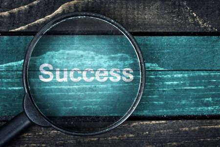 Success text painted and magnifying glass on wooden tableの写真素材