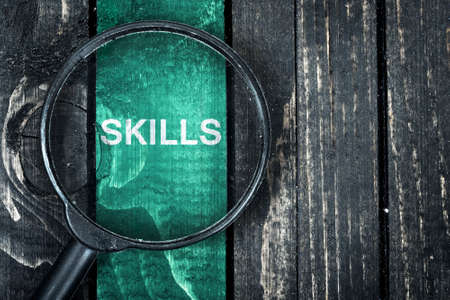 Skills text painted and magnifying glass on wooden tableの写真素材
