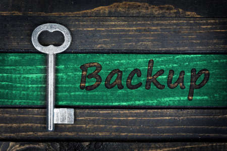 Backup word and old key on wooden tableの写真素材