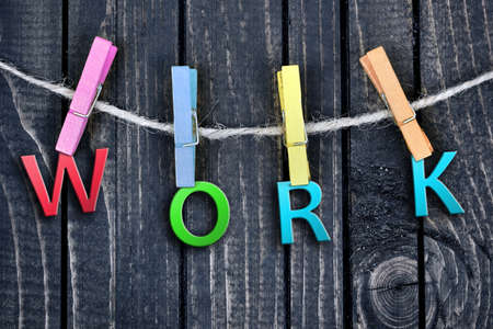 Work word hanging on clips and wooden wallの写真素材