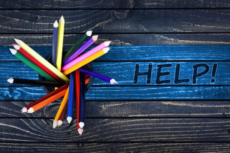 Help text painted and group of pencils on wooden tableの写真素材