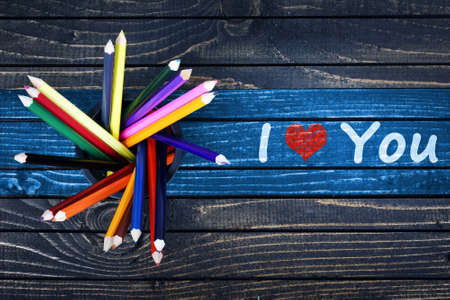 I love you text painted and group of pencils on wooden tableの写真素材