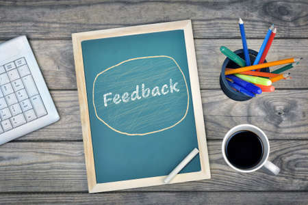 Feedback text on school board and coffee on deskの写真素材
