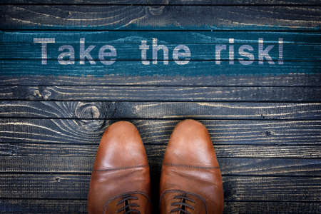 Take the risk message and business shoes on wooden floorの写真素材