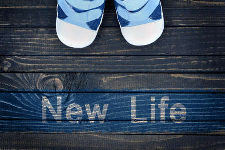 New Life message and kid shoes on wooden floorの写真素材