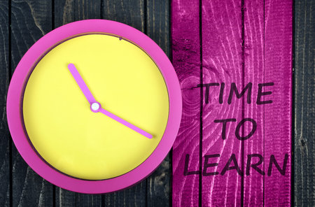Time to learn message and clock on wooden table