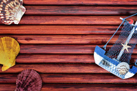 Toy ship and sea shells on blue wooden tableの写真素材