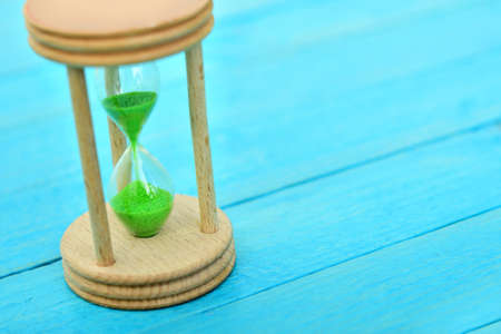 Hourglass close-up on wooden tableの写真素材