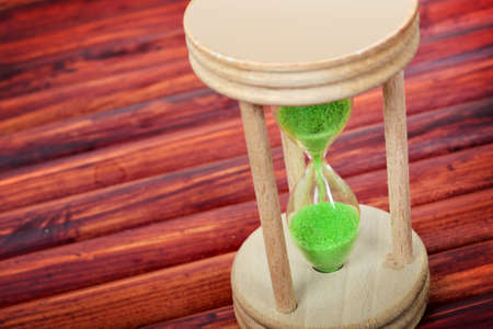 Hourglass close-up on wooden tableの写真素材