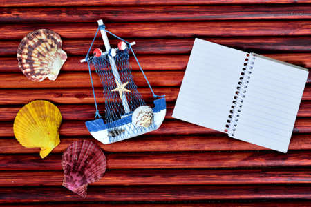 Toy ship and notepad on blue wooden tableの写真素材