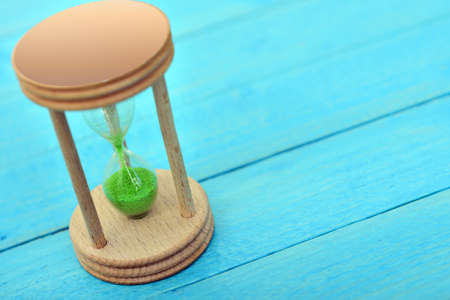 Hourglass close-up on wooden tableの写真素材