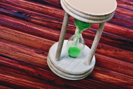 Hourglass close-up on wooden tableの写真素材