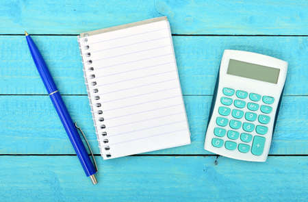 Empty notepad and calculator on wooden tableの写真素材
