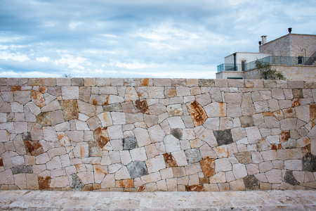 Fence made of natural stone. Street in the city of Alberobello, Italy. Vintage asymmetrical stone background.の写真素材