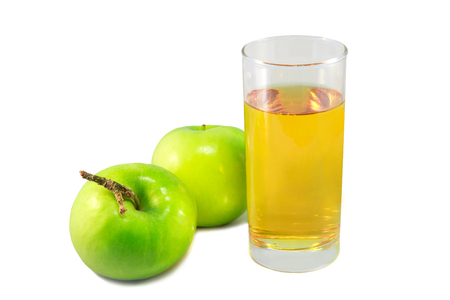 Beautiful fresh juicy green apples. A glass of apple juice on a white isolated background. A useful vitamin drink for a healthy sport diet.の写真素材