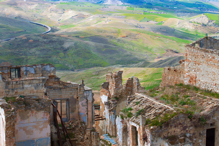 Beautiful view of green fields from a ruined town of the Basilicata region, Italy. Collapsed houses. Stone buildings with tiled roofs, destroyed by natural conditions. Tourist place and place for place for shooting movies.の写真素材