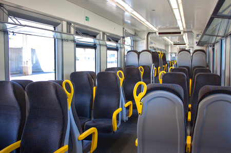 Gray blue armchairs with yellow handles in an empty train. Seats without passengers. Euro-tripの写真素材