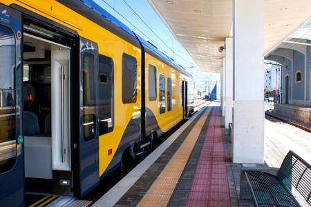 Beautiful yellow train with open door at a station in Europe. The platform goes into perspectiveのeditorial素材