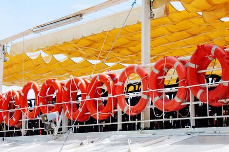 Lifebuoys hang on board the ship under yellow roof to rescue people (tourists) in the event of a fall into the water and in an emergencyの写真素材