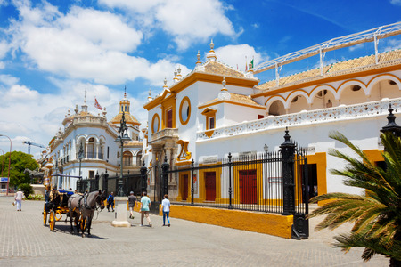 Seville, Spain, June 07, 2018: The bullring (Plaza de toros). Main entrance in old bullfight arena and ticket office in summer time. Horse drawn for tourists, blue sky in sunny dayのeditorial素材