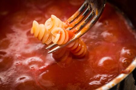 italy. Italian fusilli pasta dipped in tomato and basil sauceの写真素材