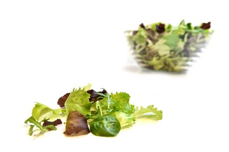 shot on a white background total white of a glass bowl with a mixed salad only green field tender and good to seasonの写真素材