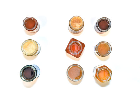 different honey jars from the top on a withe background