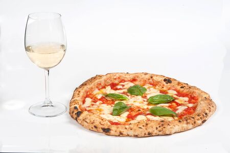 real italian pizza margherita with mozzarella cheese, in a white background  whit a glass of delicious Italian white wine の写真素材