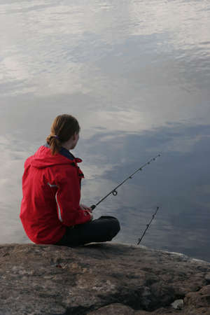 The girl fishs on north lakeの写真素材
