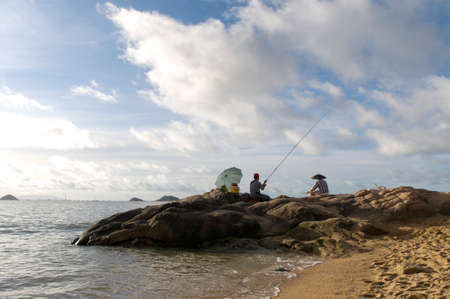 Two man fishing at the beachの写真素材