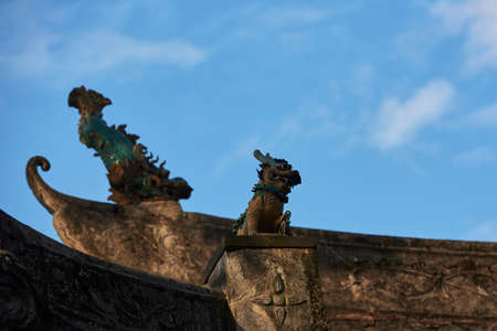 Dragon figurine on the top of houseの写真素材