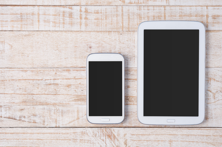 Tablet and phone  on white wood.Copy spaceの写真素材