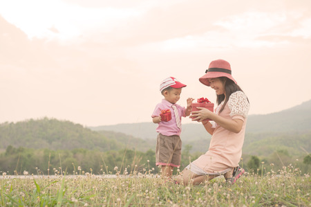 A mother and son giving gift box on outdoorsの写真素材