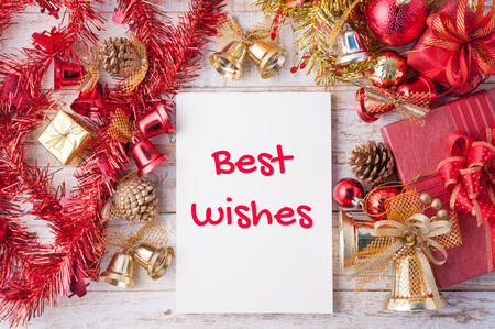Best wishes word on notebook and Christmas gift box with decorations and note paper on white wood background.の写真素材