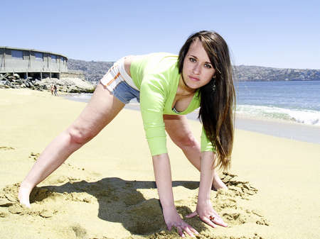 Sporty girl stretching at the beachの写真素材