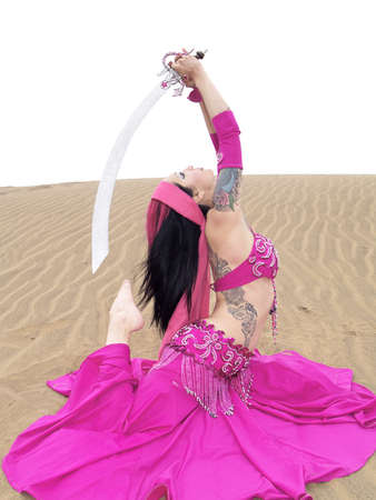 Arab dancer posing with a sword at desertの写真素材
