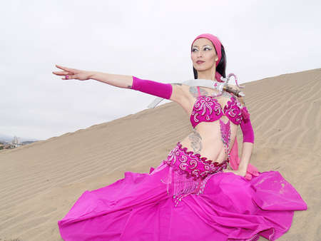 Pose of an arab dance at dunes with a swordの写真素材