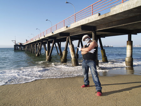 A rapper poses near a dock at seasideの写真素材
