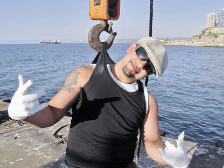 A rapper poses on a lonely dock with a craneの写真素材