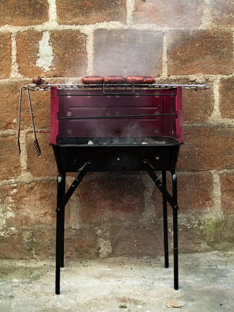 Sausages grilling cooking near a wallの写真素材