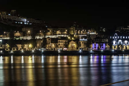 Oorto, December 2012. View of Vila Nova de Gaia at the opposite side of Douro river. Some buildings and commerces at night. 300,000 population, origins on Roman Empire.のeditorial素材
