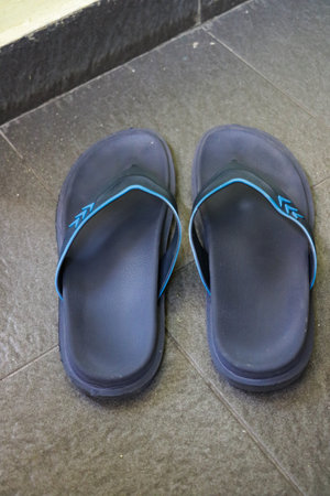 A pair used of Navy blue rubber flip-flops pair of thongs, shot above.