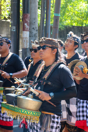Bali, Indonesia 22 June 2023. A group of local balinese people playing traditional music instrument called gamelan during cremation ceremony on midday.のeditorial素材