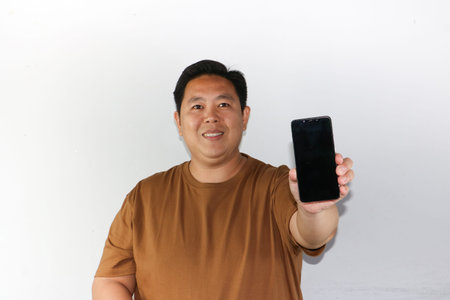 Happy gesture and smiling face of Asian man showing his smartphone blank screen.