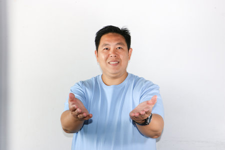 Smiling Man wearing blue tshirt showing Open Handsの写真素材