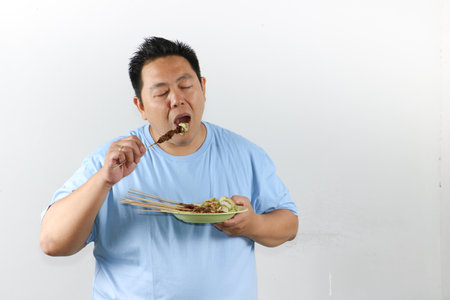 Man Enjoying Delicious Satayの写真素材