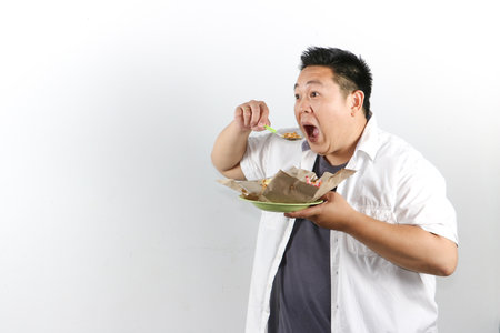 Hungry Man Enjoying a Delicious Indonesian Fried Rice with mouth open widelyの写真素材
