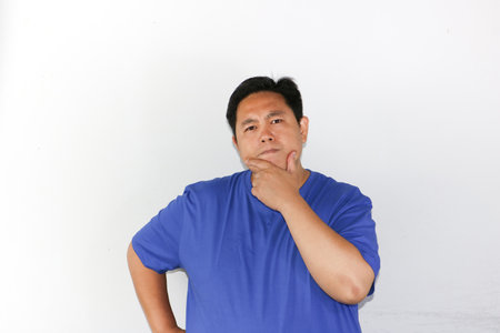 Suspicious expression Asian Man holding his chinの写真素材